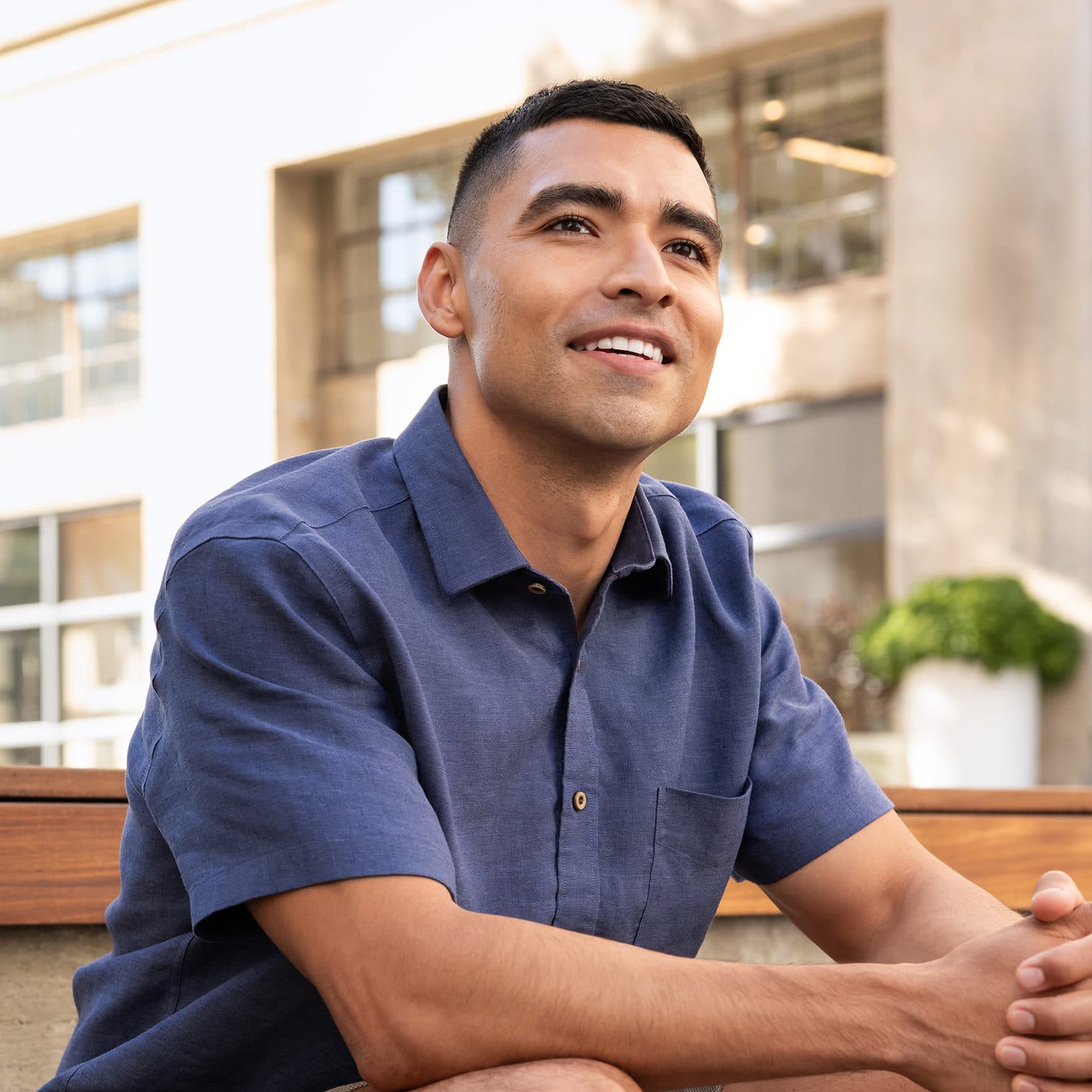 Man smiling sat on a bench