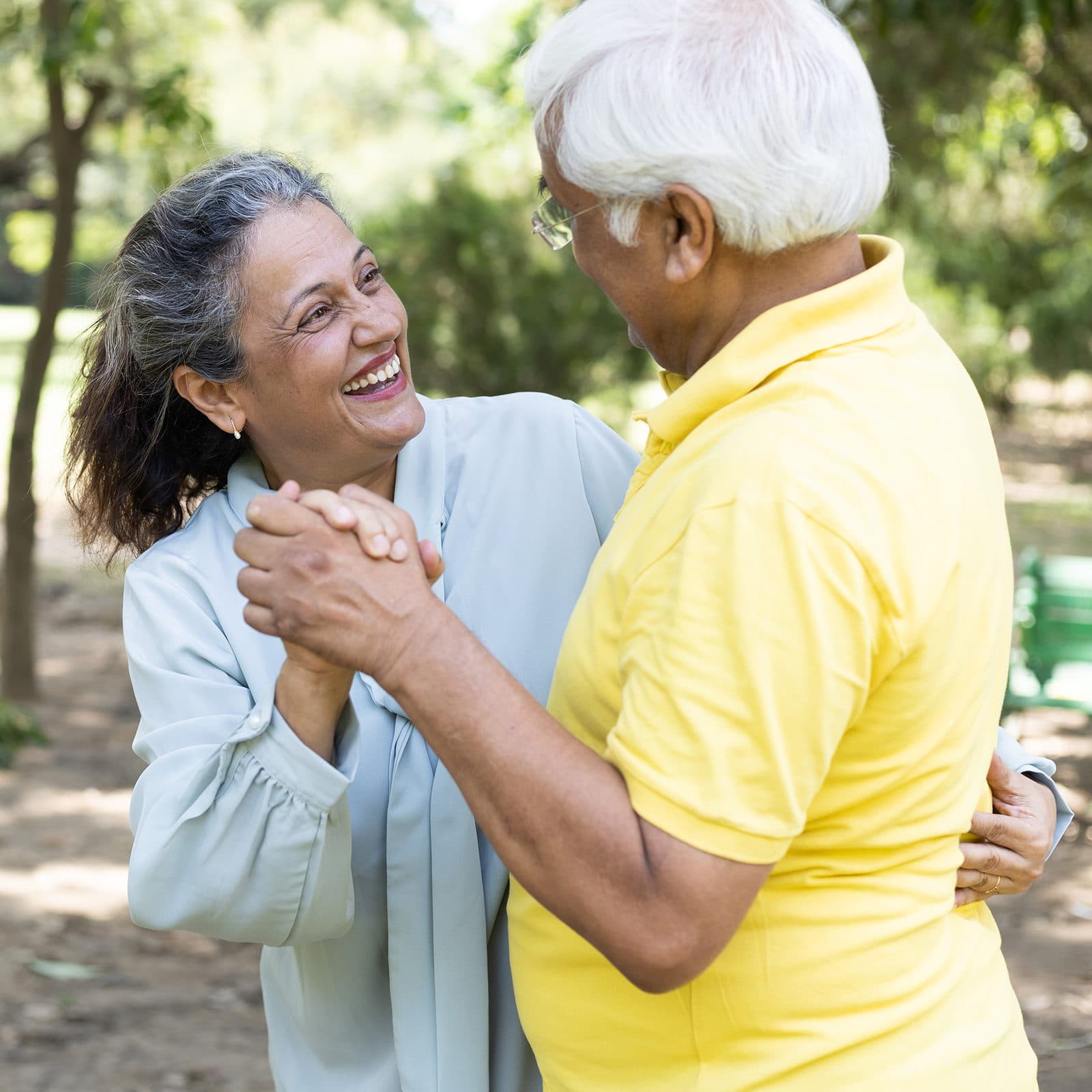 Older couple smiling and embracing in the park