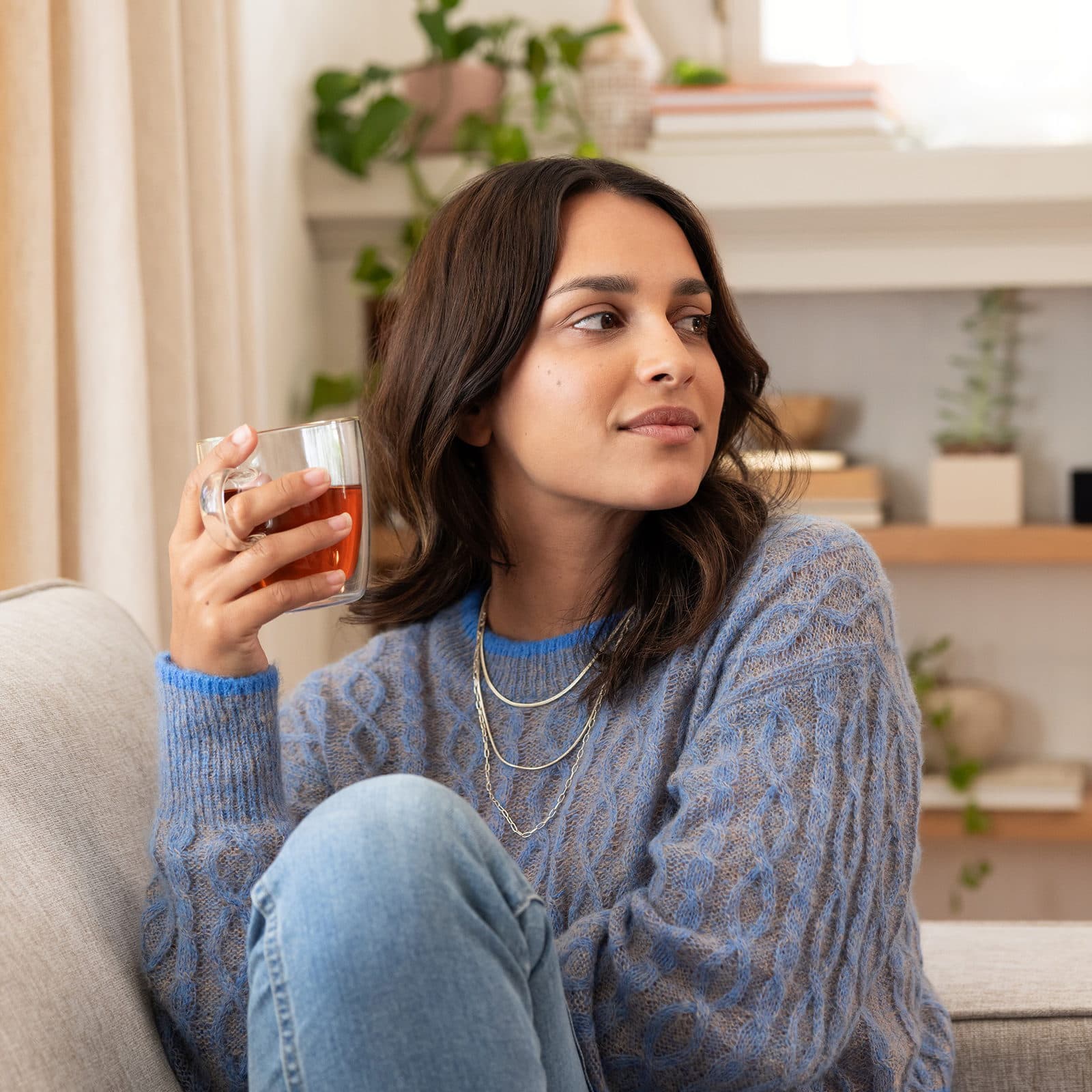 Woman at home holding cup of tea