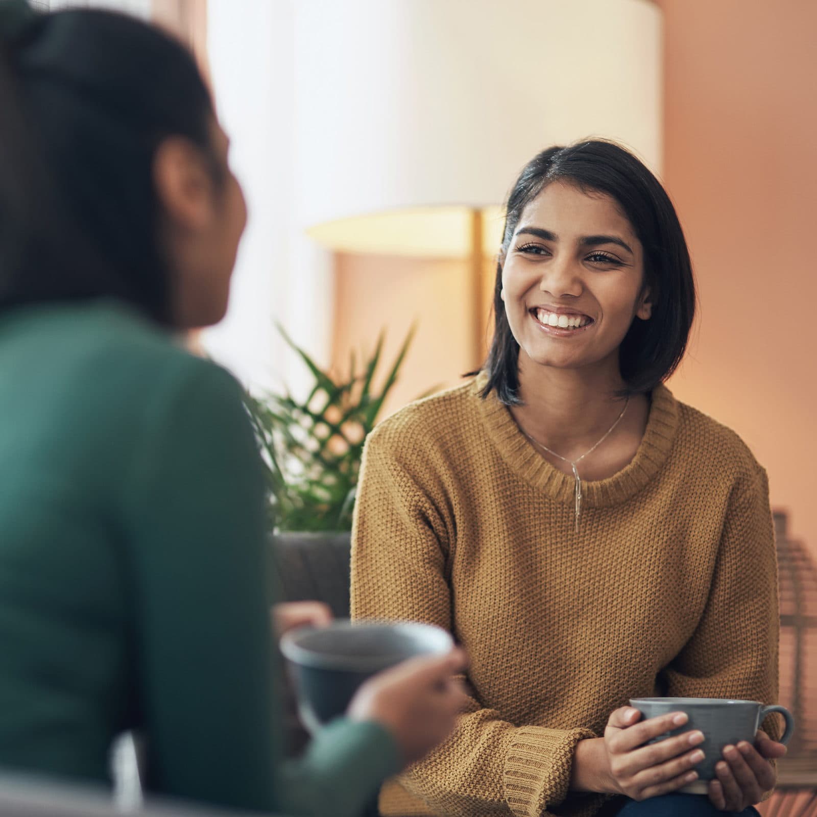 two women having friendly conversation with a cup of tea